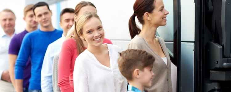 Happy people lined up to get on Miami charter bus